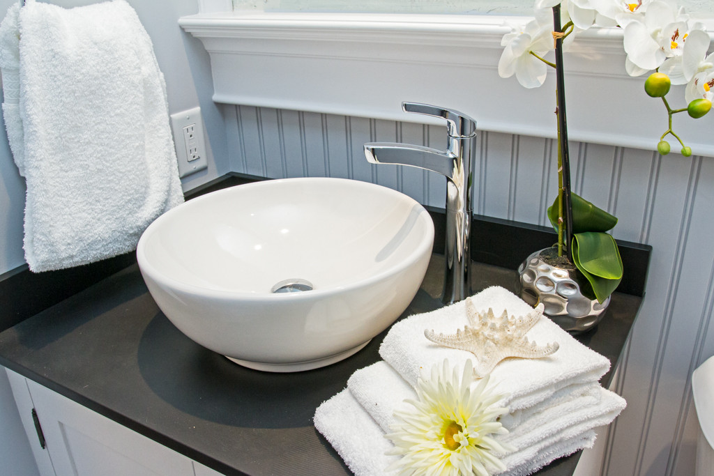 beautifully staged bathroom counter with bowl sink and towels